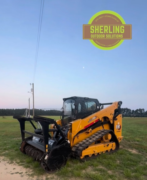 Compact track loader with mulching head on a cleared field